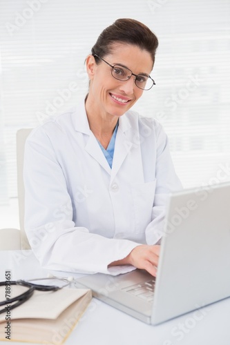 Happy doctor using laptop