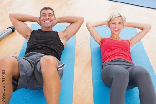 Happy fit couple working on exercise mat