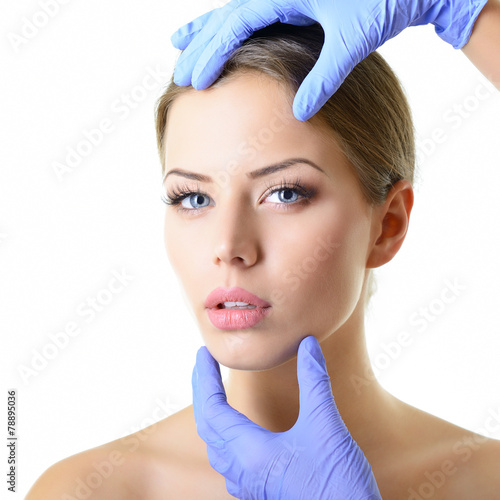 Beauty treatment of the young beautiful female face, doctor's ha