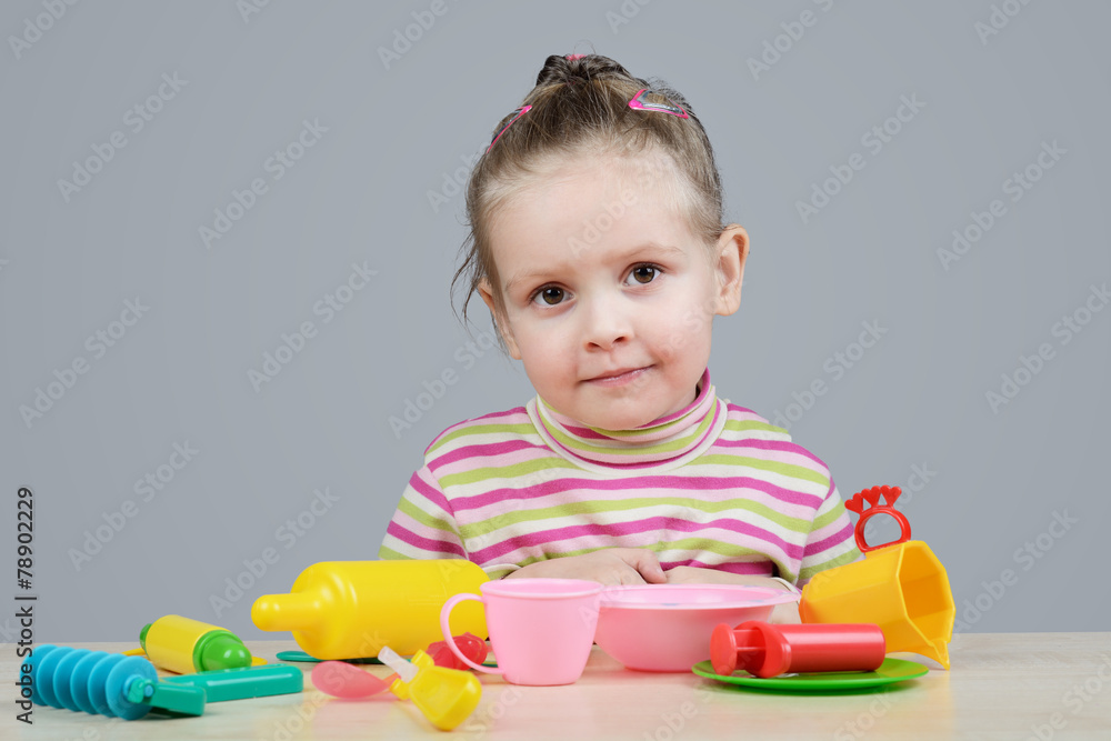 Girl playing with plastic tableware