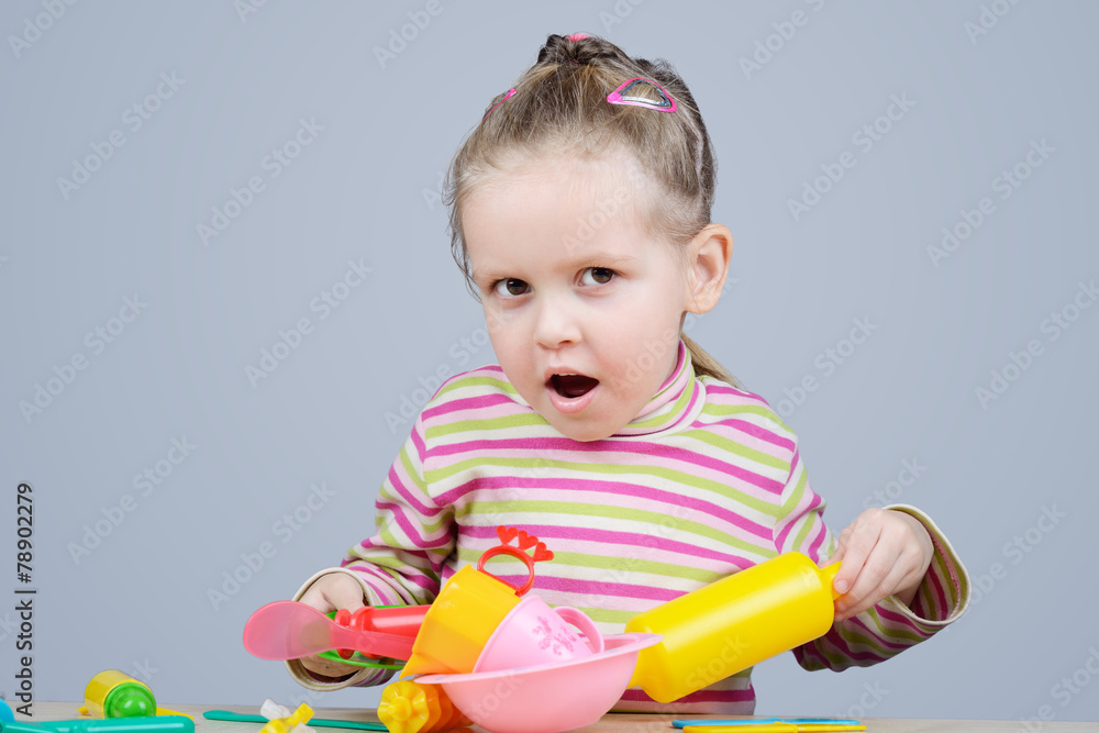 Girl playing with plastic tableware
