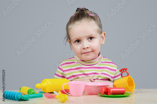 Obraz na płótnie Girl playing with plastic tableware w salonie