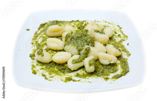 Gnocchi with basil pesto on white background