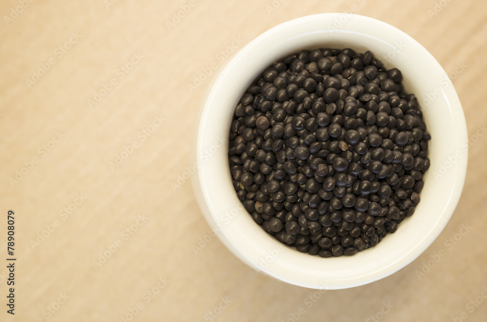 black lentils in a porcelain cup close up black lentils in a porcelain cup close up