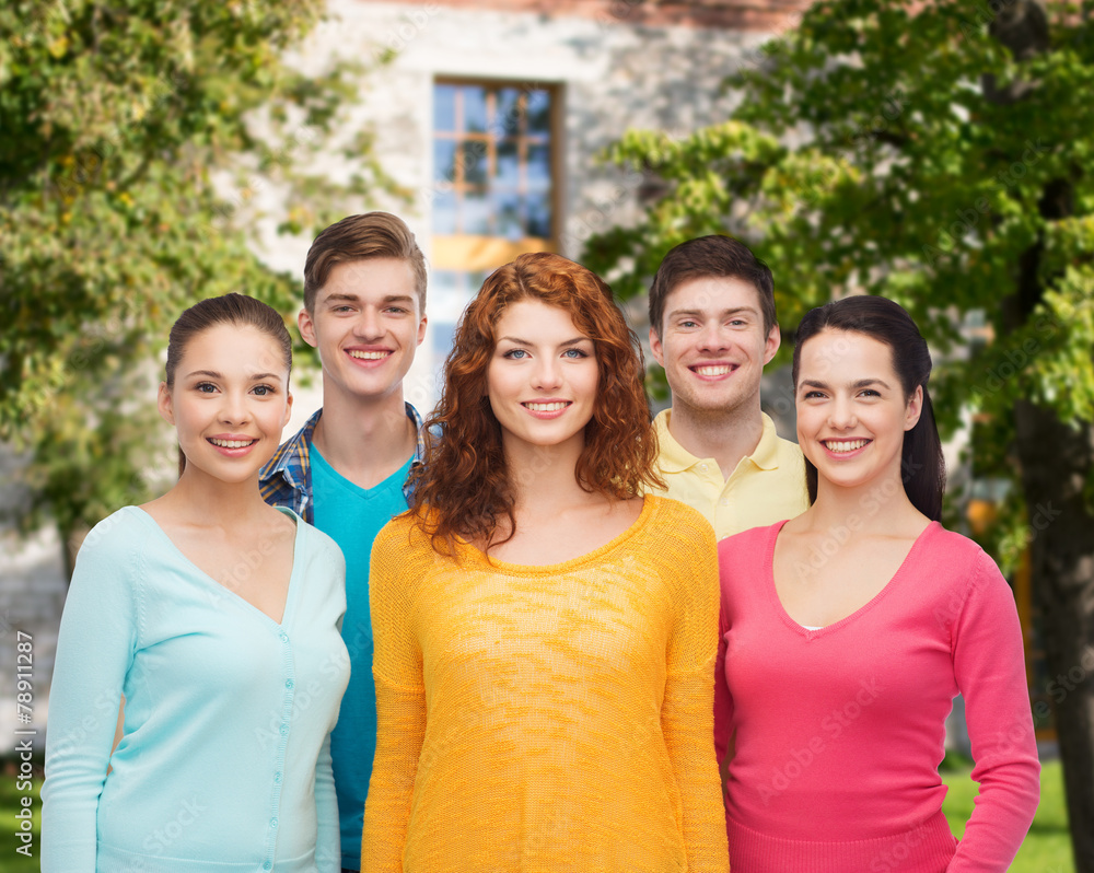 group of smiling teenagers over campus background group of smiling teenagers over campus background