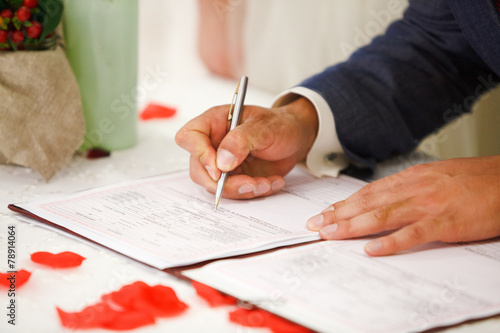 Принти на полотні groom signs marriage certificate with a pen