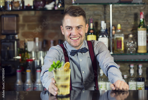 young man working as a bartender in a nightclub bar