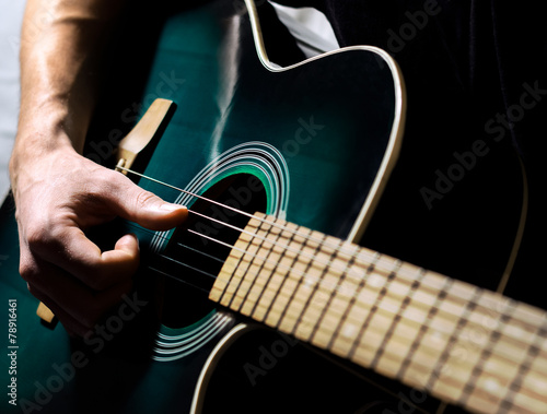 A man musician playing on the guitar