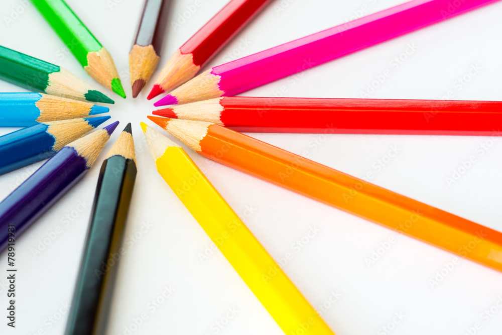 Colored pencils in a circle on the paper in corner. Angle view Colored pencils in a circle on the paper in corner. Angle view