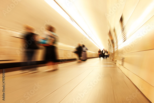 Motion blurred commuters in subway station.