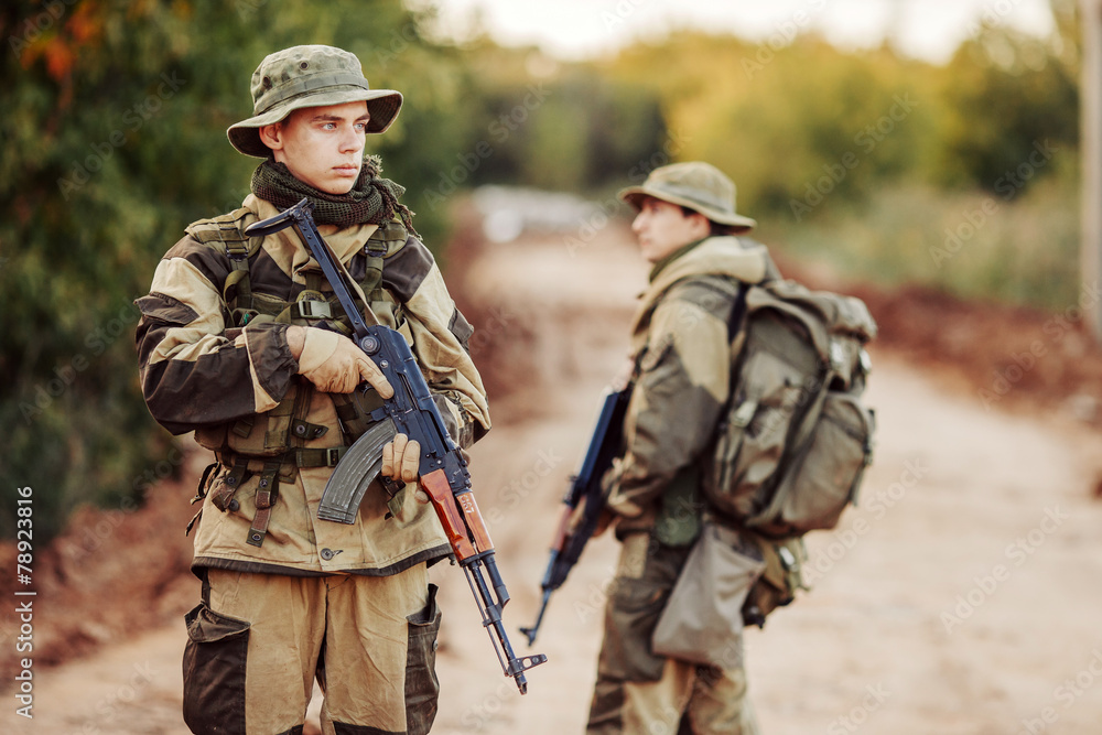 Fototapeta premium Two soldiers are exploring an unfamiliar area