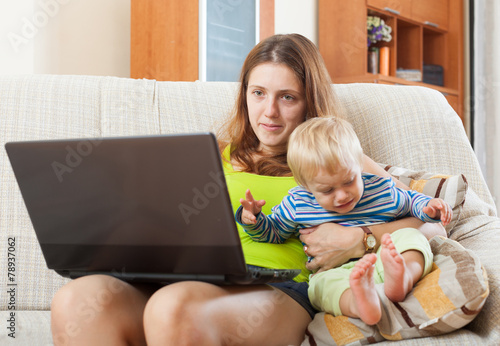 mother with crying baby working online photo