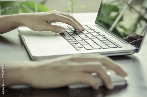 Woman using a mouse working on the computer