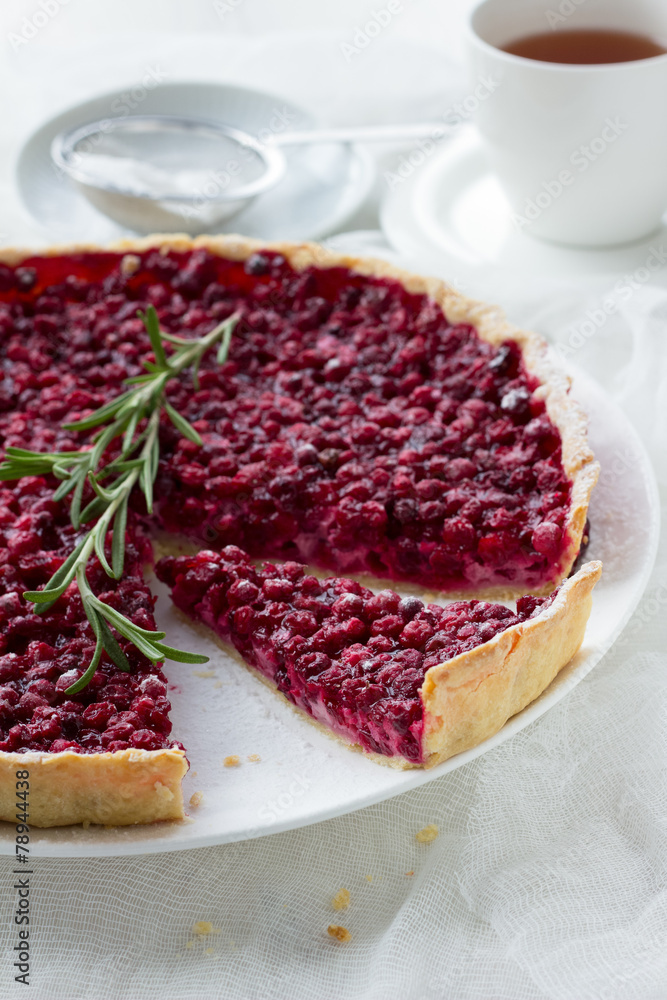 Red bilberry tart with a cup of tea