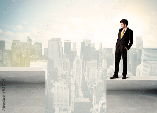 Businessman standing on the edge of rooftop © ra2 studio