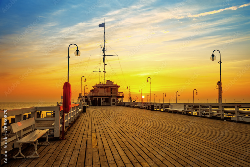 Obraz premium Wschód słońca przy drewnianym molem w Sopocie, Polska.