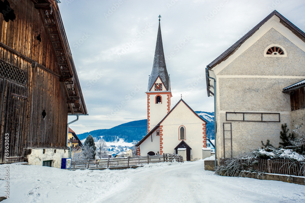 old catholic church in small Austrian town covered by snow