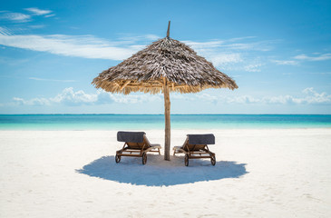 Acrylglasbilder Sansibar Zwei Liegestühle unter Strohdach am Zanzibar Strand  © Marko Balenovic