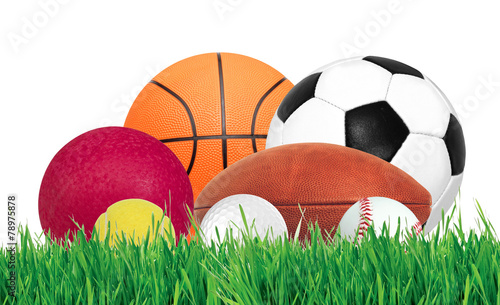Sports balls over green grass isolated on white