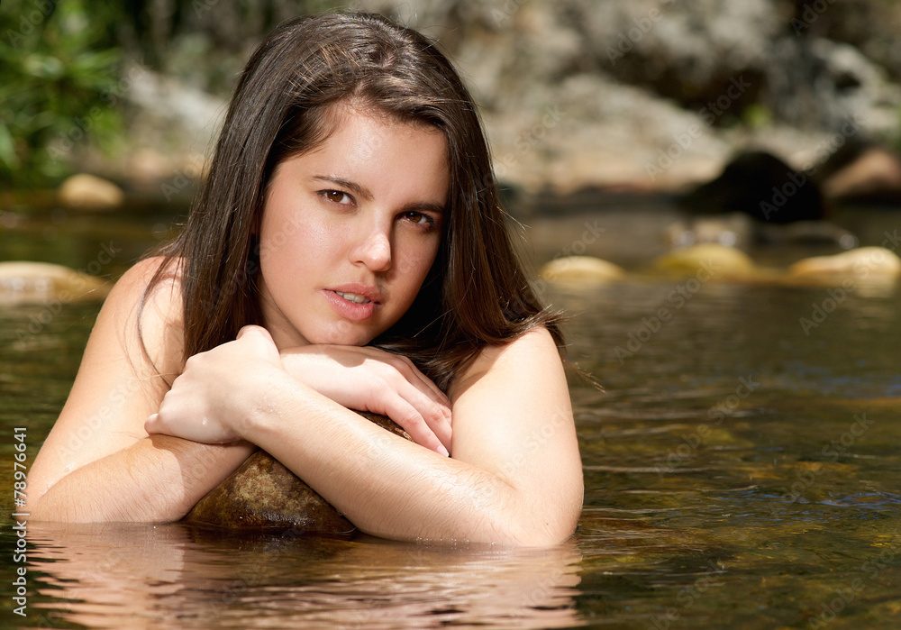 Beautiful young woman relaxing in water in summer