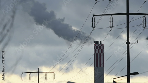 Smoking smoke stack of a power plant and power lines