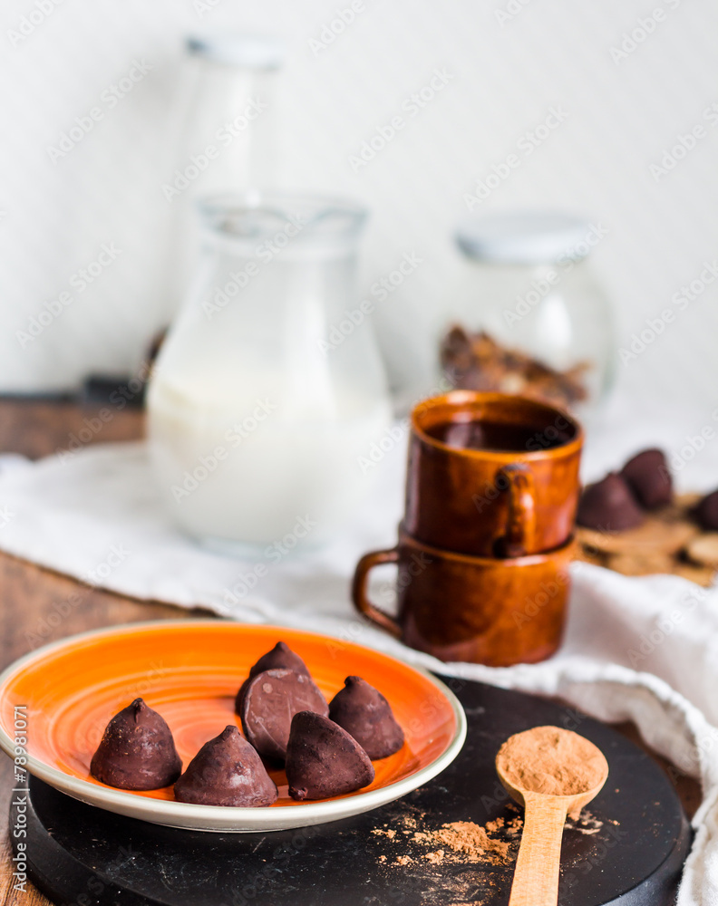chocolate truffles, cocoa powder in a wooden spoon chocolate truffles, cocoa powder in a wooden spoon