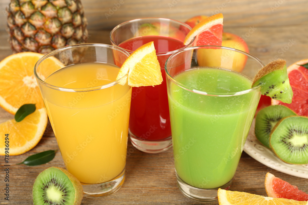 Fresh juices with fruits on wooden table Fresh juices with fruits on wooden table