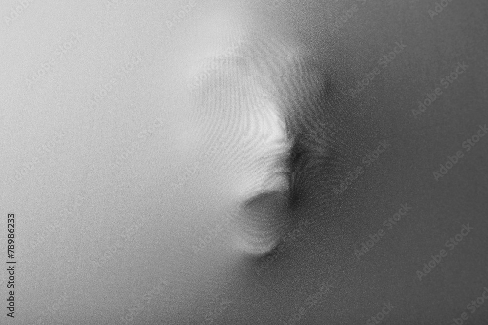 Screaming human face pressing through fabric as horror Screaming human face pressing through fabric as horror