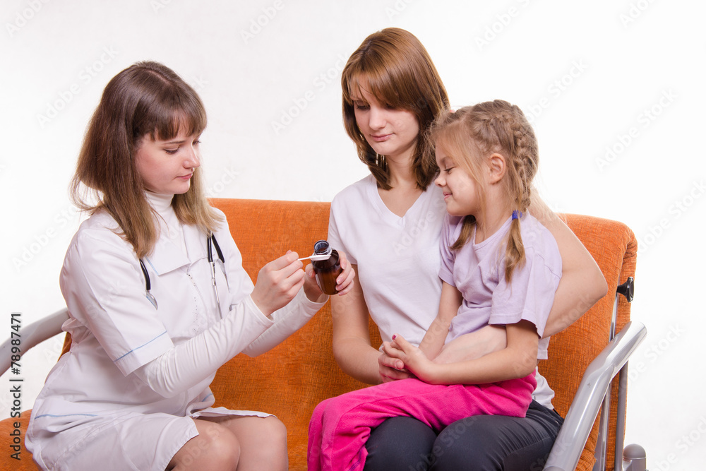 Pediatrician is going to give a sick child medicine from spoon Pediatrician is going to give a sick child medicine from spoon
