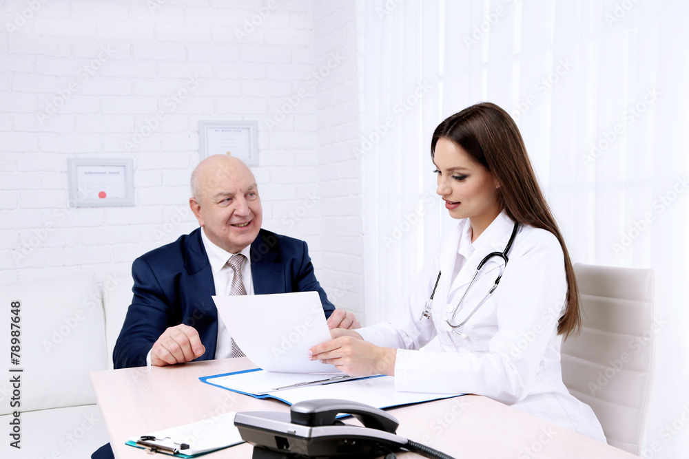Young female doctor receiving patient in her office