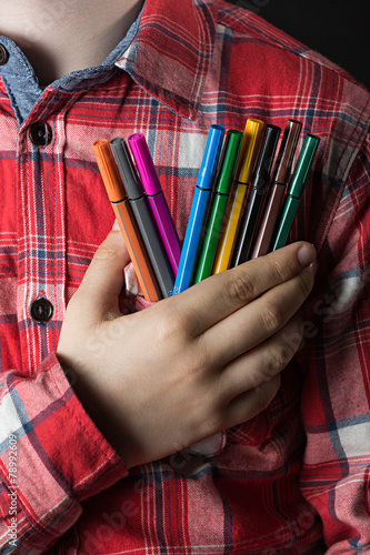 Niño con rotuladores de colores en la mano.