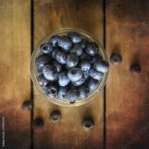 Blueberries in rustic kitchen setting with old wooden background photo