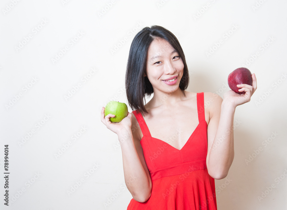 Asian woman smiling with green and red apples on her hands Asian woman smiling with green and red apples on her hands