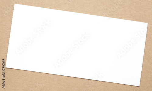 Blank white paper note on brown paper background © torsakarin
