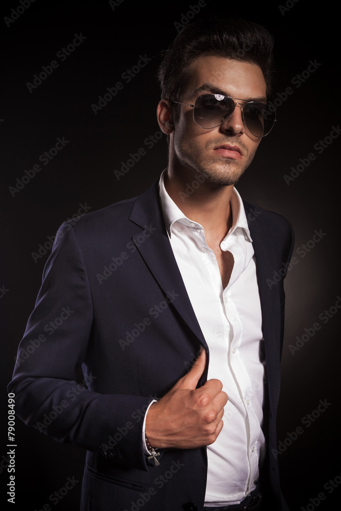 Elegant young business man arranging his jacket Elegant young business man arranging his jacket