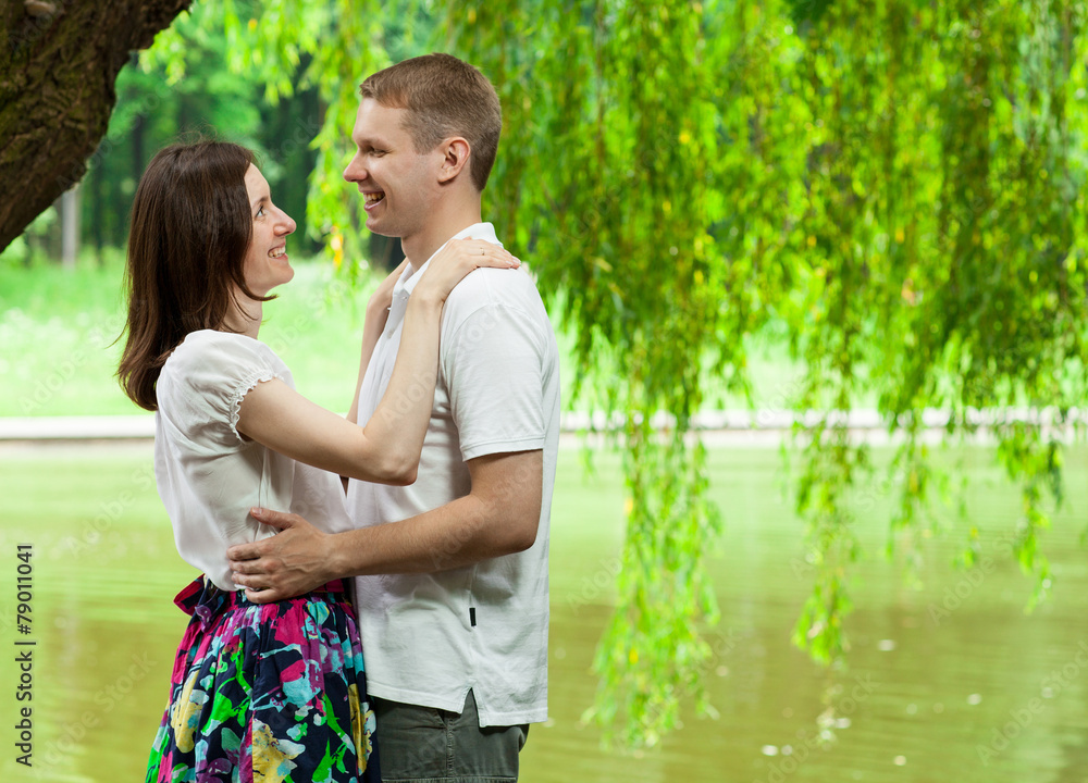 Fototapeta premium Cute young couple under green willow
