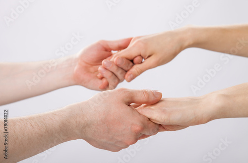Two pairs of hands holding each other