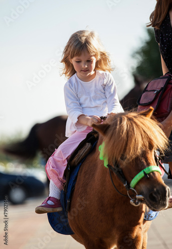 Happy smiling little girl  on a pony © zest_marina