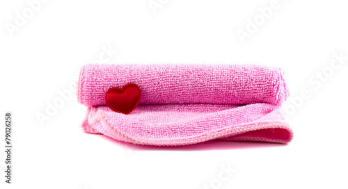 Pink towel and red heart rolled up on a white background