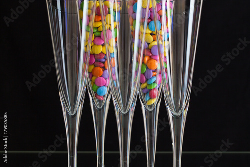 Color chocolate smarties inside the champagne glasses photo