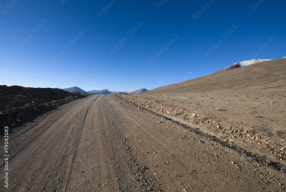 Beautiful landscape - country road in desert valley. The rocky m