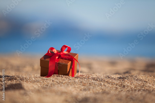 Terracotta color gift box ona beach