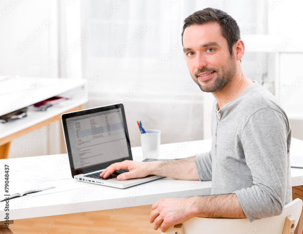 Young smiling man in front of a computer Young smiling man in front of a computer