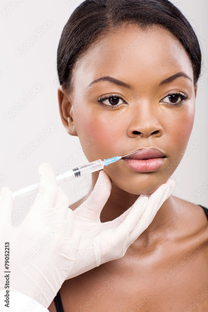 afro american woman receiving cosmetic injection in her lips afro american woman receiving cosmetic injection in her lips