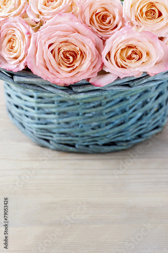 Pink roses in turquoise wicker basket