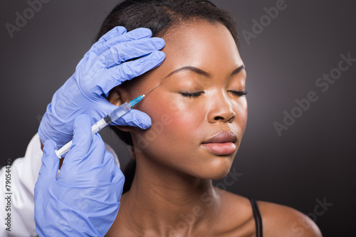 young woman receiving cosmetic injection on her face