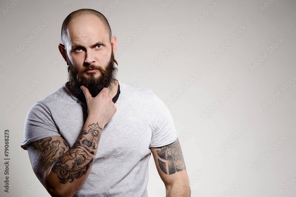 Obraz premium Bearded tattooed man wearing white blank t-shirt