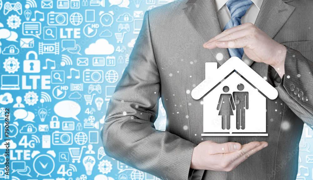 businessman protecting family in home with hands