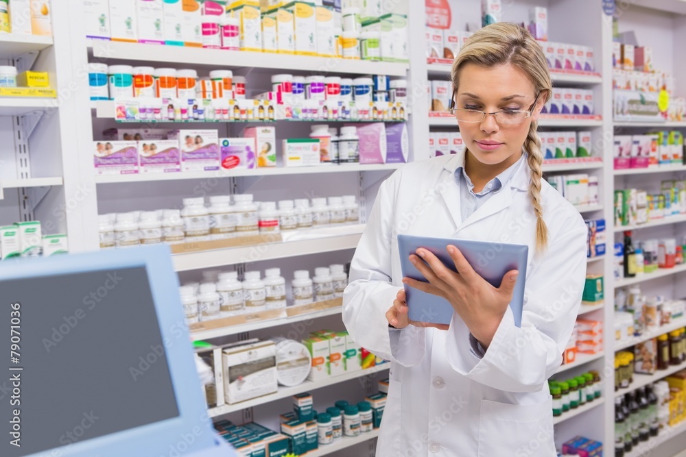 Junior pharmacist using tablet pc Junior pharmacist using tablet pc