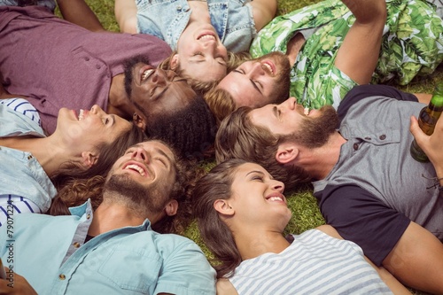 Happy young friends lying on grass